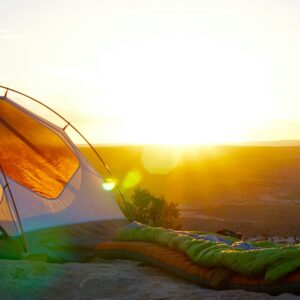 camping tent on cliff during golden hour